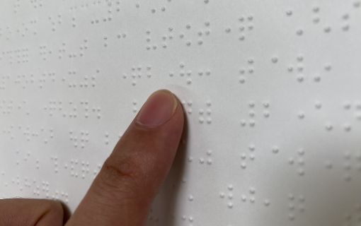 点字を人差し指で読んでいる写真